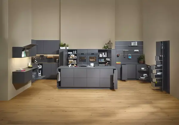 Moderne Einbauküche mit grauen Fronten, Kochinsel und offenen Regalen auf Holzfußboden.