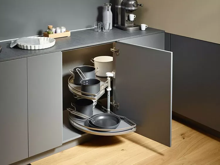 Eckunterschrank in moderner Küche mit ausziehbarem Rondell und Kochgeschirr.