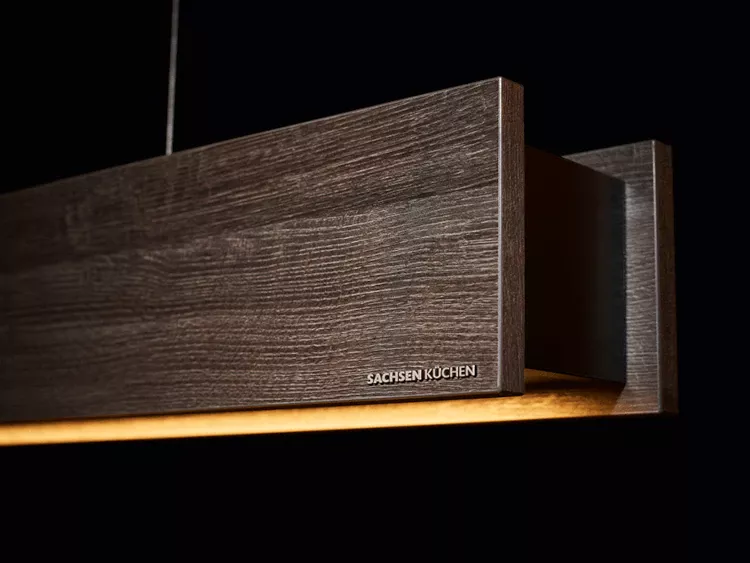 Moderne LED-Küchenlampe aus dunklem Holz im minimalistischen Design von Sachsen Küchen.